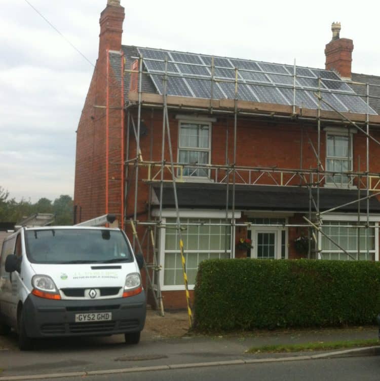 image of scaffolded home with solar panels on roof