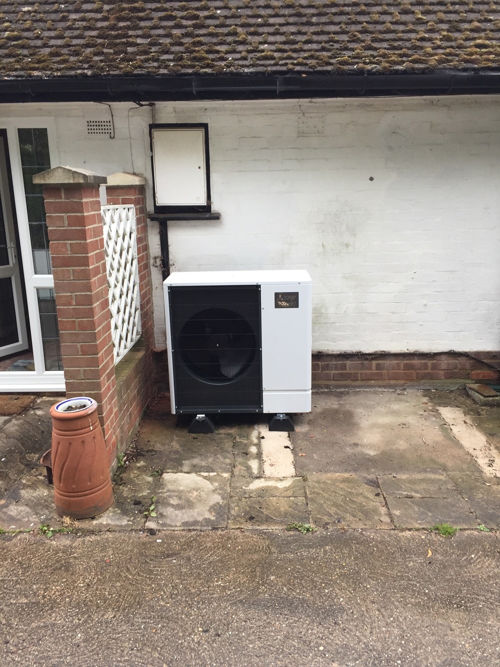 image of air source heat pump around rear of clients house