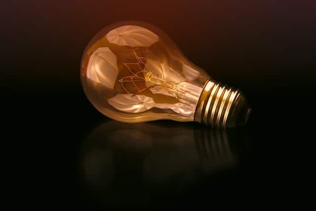 energy efficiency myths, light bulb placed on darker surface