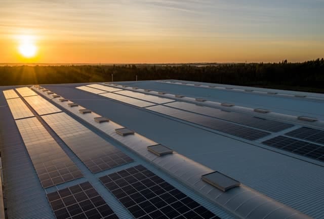 Solar Panel Maintenance; solar panels installed uniformly, on top of a building in an open space